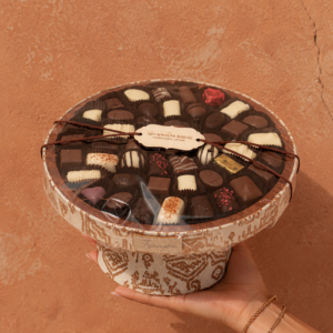 Support sur pied en tissu amazigh sublimée par une sélection de chocolats.